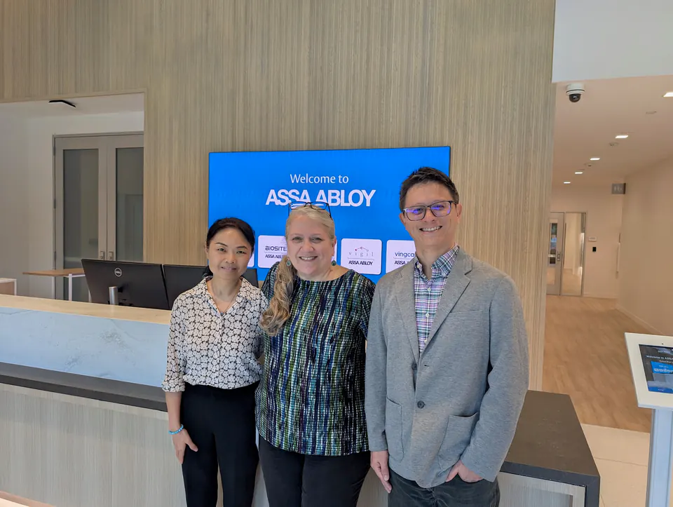 Charley 与参访人员在 ASSA ABLOY 标识前合影