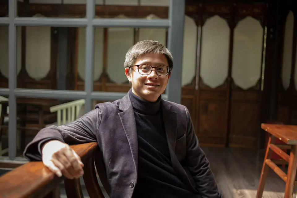 OFD 创始人 Charley Shen 坐在木栏旁